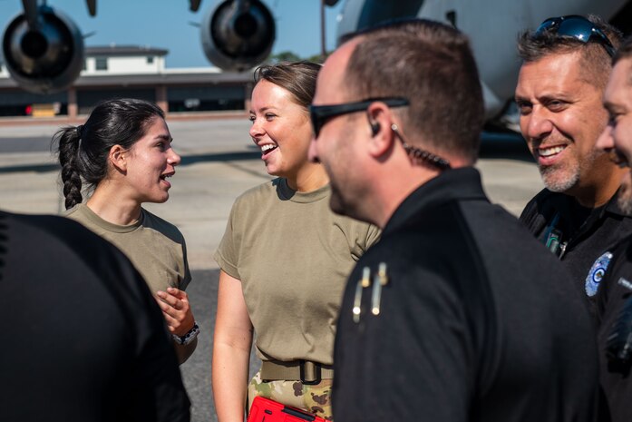 U.S. Air Force Airmen from the 15th and 16th Airlift Squadrons and personnel from the North Charleston Police Department, discuss training at Joint Base Charleston, South Carolina, Sept.16, 2022. In an effort to strengthen joint efforts, the NCPD provided two Mine Resistant Ambush Protected Vehicles, or MRAPs, for loadmasters to practice loading onto a C-17 Globemaster III aircraft. (U.S. Air Force photo by Airman 1st Class Christian Silvera)