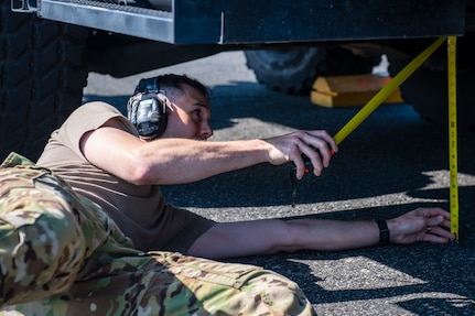 U.S. Air Force Tech. Sgt. Stephen Stafford,15th Airlift Squadron air and land loadmaster, measures the distance from a  police Mine Resistant Ambush Protected Vehicle, or MRAP, to the ground during a joint training exercise with the North Charleston Police Department at Joint Base Charleston, South Carolina, Sept.16, 2022. Loadmasters are responsible for properly loading, securing and escorting cargo and passengers on an aircraft. (U.S. Air Force photo by Airman 1st Class Christian Silvera)