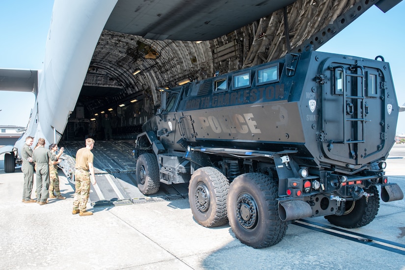 U.S. Air Force Airmen from the 15th and 16th Airlift Squadrons watch as loadmasters load a police Mine Resistant Ambush Protected Vehicle, or MRAP, onto a C-17 Globemaster III during a joint training exercise with the North Charleston Police Department at Joint Base Charleston, South Carolina, Sept.16, 2022. The MRAP is capable of driving through all sorts of terrain, including deep snow, mud, dirt and water. (U.S. Air Force photo by Airman 1st Class Christian Silvera)