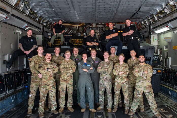 U.S. Air Force Airmen from the 15th and 16th Airlift Squadrons and personnel from the North Charleston Police Department pose for a group photo during a joint training exercise at Joint Base Charleston, South Carolina, Sept.16, 2022. The exercise prepared loadmasters to load larger vehicles onto a C-17 Globemaster III aircraft - a potential wartime scenario. (U.S. Air Force photo by Airman 1st Class Christian Silvera)