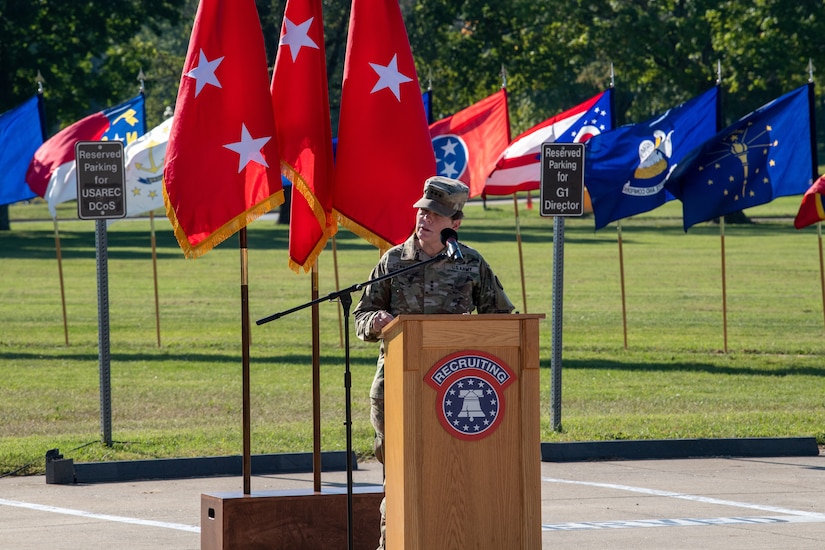 woman in u.s. army uniform gives a speech at a podium