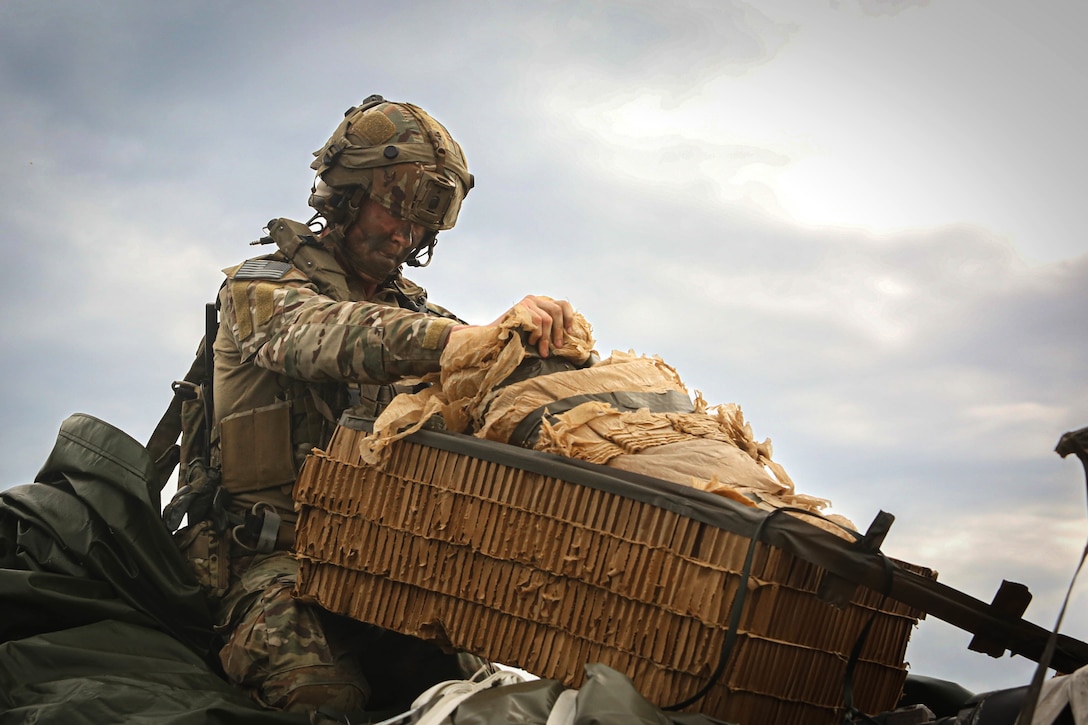 A soldier interacts with equipment.