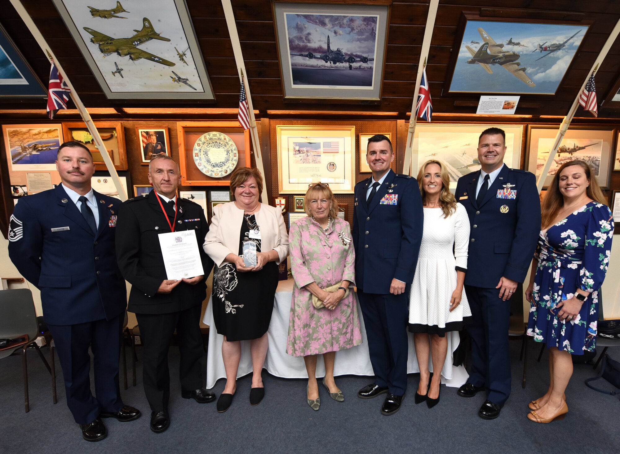 Long-time volunteers at the 100th Bomb Group Memorial Museum, along with Royal Air Force Mildenhall leadership and spouses, proudly show off their Queen’s Award for Voluntary Service, presented by The Lady Dannatt, center, MBE, HM Lord-Lieutenant of Norfolk, at Thorpe Abbotts, Norfolk, England, Sept. 8, 2022. The award, signed by the Queen, is the highest award given to volunteer groups across the United Kingdom, and became poignant and bittersweet as it was presented on the day Her Majesty Queen Elizabeth II passed away. Only two volunteer groups in Norfolk received the award as part of the Platinum Jubilee and in recognition of extraordinary service to the community. The 100th Air Refueling Wing’s heritage dates back to the 100th Bomb Group and the museum is dedicated to Airmen of the Eighth Air Force who served during World War II. (U.S. Air Force photo by Karen Abeyasekere)