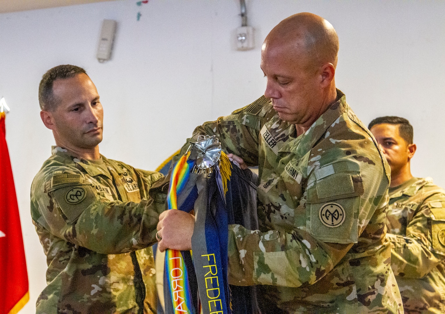 U.S. Army Lt. Col. Shawn Tabankin, the commander of 1st Battalion, 69th Infantry Regiment, and Command Sgt. Maj. Jason Zeller, the 1st Battalion, 69th Infantry Regiment, senior enlisted leader, unfurl the unit’s colors during a transfer-of-authority ceremony at Camp Lemonnier, Djibouti, Sep. 19, 2022. During the ceremony, more than 1,100 New York Army National Guard Soldiers officially began their service as part of Combined Joint Task Force – Horn of Africa.