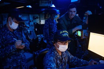 JMSDF officers discusses surface-force maritime tactics with U.S. naval officers aboard USS Ronald Reagan (CVN 76) in the Philippine Sea.
