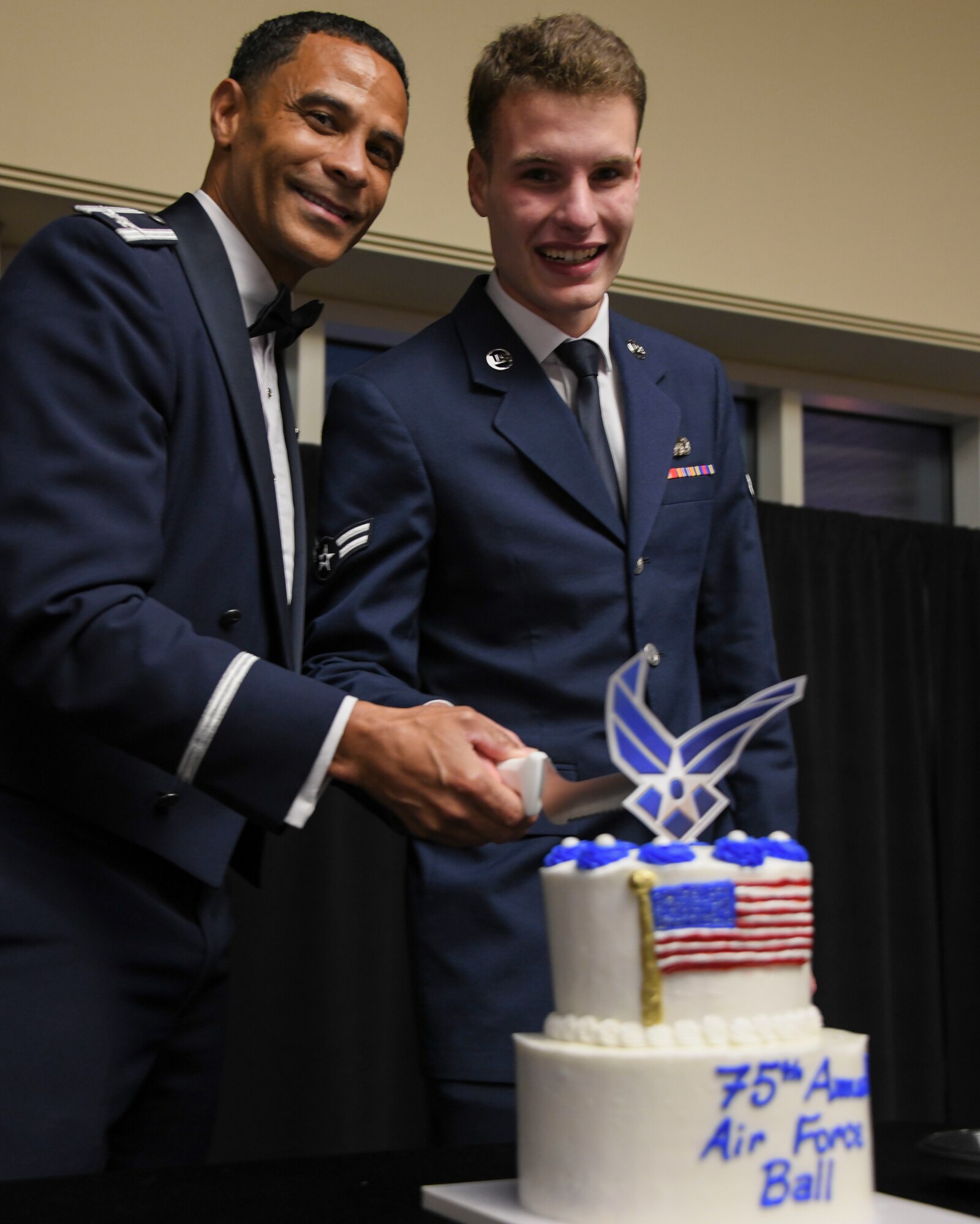 U.S. Air Force Col. Timothy Curry, 319th Reconnaissance Wing commander, and U.S. Air Force Airmen 1st Class Cable Spicklemire, 319th Force Support Squadron relocation technician, cut a cake Sept. 16, 2022, during the 319th RW’s celebration of the Air Force’s 75th birthday at the Ralph Englestad Arena in Grand Forks, North Dakota. The theme for the ball called airmen to “Innovate, Accelerate and Thrive,” to celebrate what the Air Force was able to accomplish over the past 75 years of service and to look forward to a bright future. (U.S. Air Force photo by Senior Airman Roxanne A. Belovarac)