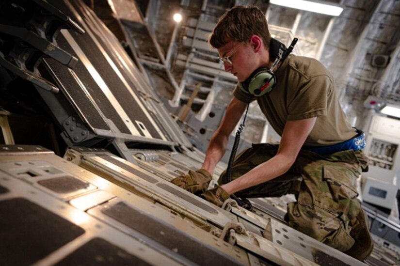 Man sets up rails on C-17 ramp