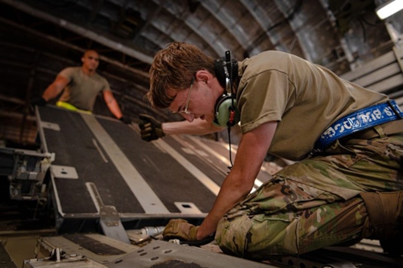 Man sets up rails on C-17 ramp