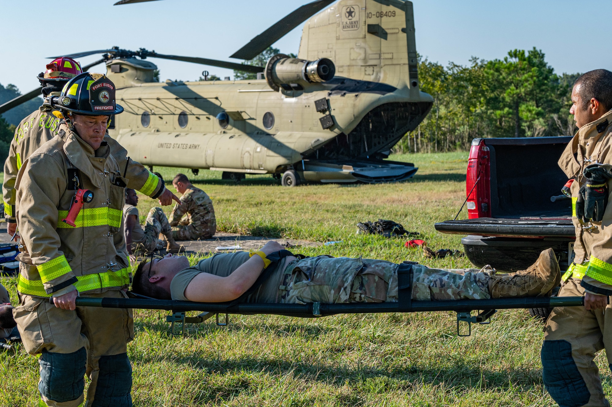 Jason Winters (left) and Joseph Cook, firefighters with Fort Eustis Fire and Emergency Services, carry simulated victim on a stretcher for evacuation during the aircraft down exercise at Joint Base Langley-Eustis, Virginia, Sept. 20, 2022.