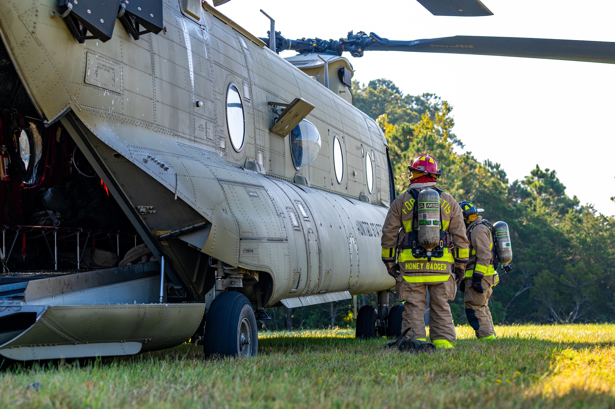 Mel Vermillion, Lt. firefighter and Mike Evans, firefighter with Fort Eustis Fire and Emergency Services, inspect the CH-47 Chinook helicopter after the simulated crash during the aircraft down exercise at Joint Base Langley-Eustis, Virginia, Sept. 20, 2022.