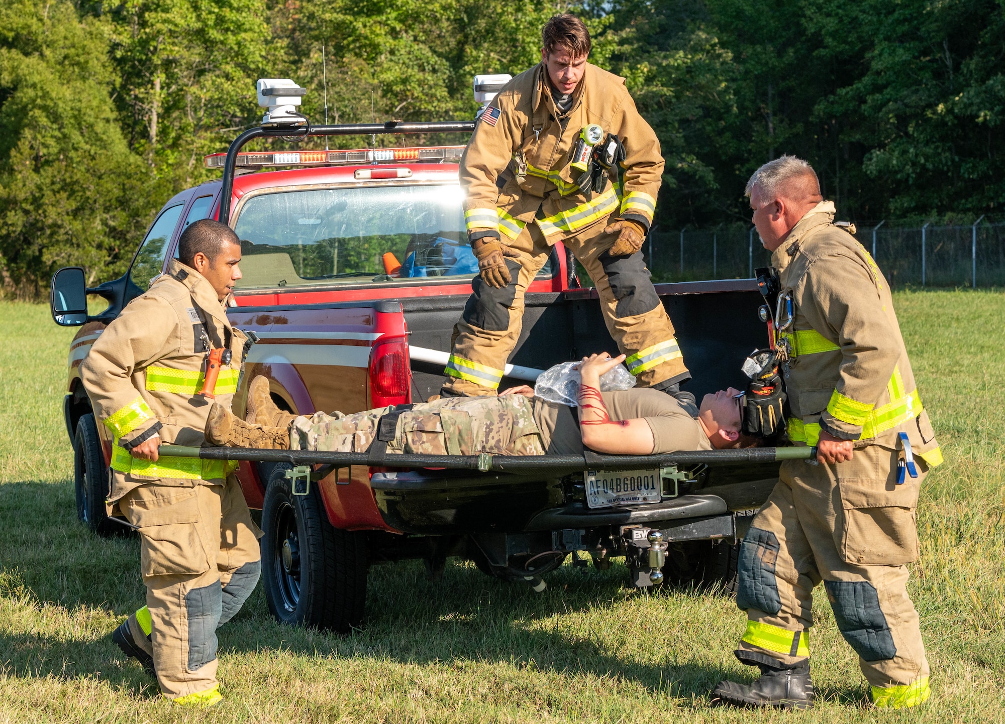 Firefighters with Fort Eustis Fire and Emergency Services load a player into a truck to evacuate him to the nearest medical facility during the aircraft down exercise at Joint Base Langley-Eustis, Virginia, Sept. 20, 2022.