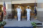 Capt. Jeremy Hawker and Capt. David Thomas on standing and saluting on stage during their change of command ceremony.