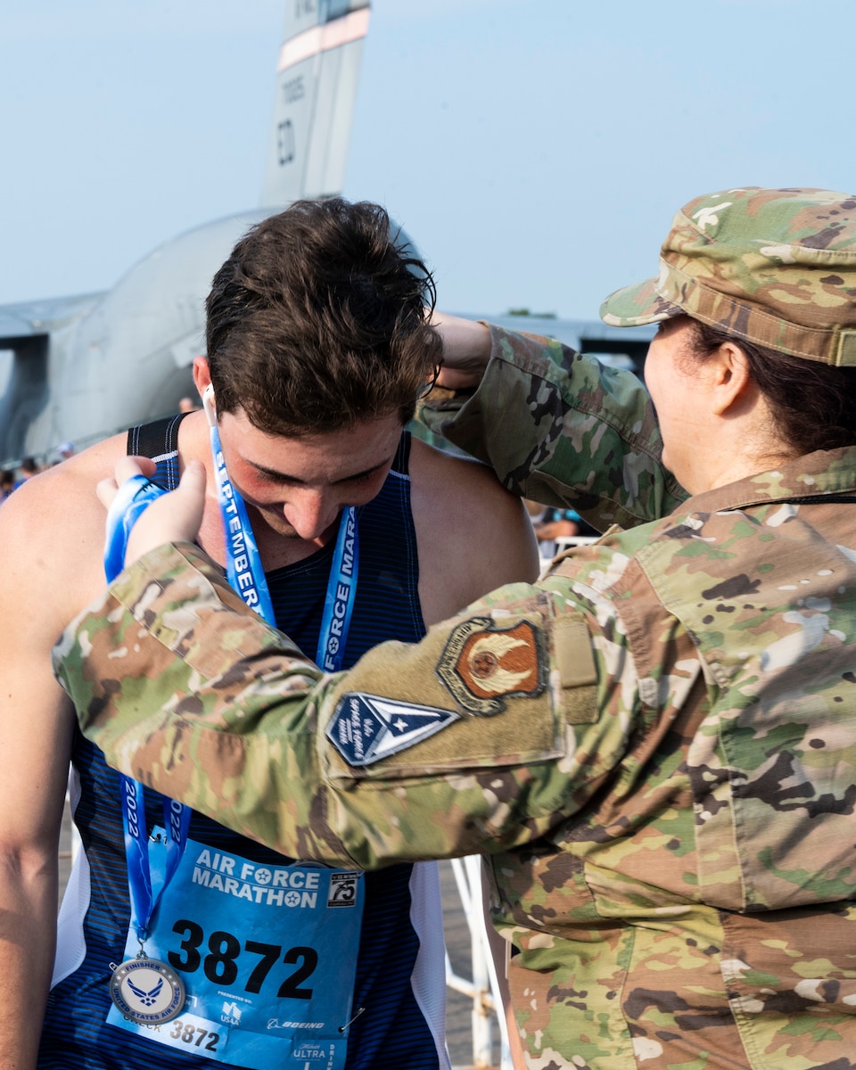 U.S. Air Force Airmen hand out medals to Air Force Marathon race finishers at Wright-Patterson Air Force Base, Ohio, Sept. 17, 2022. More than 8,500 runners and 1,500 volunteers from all 50 states and 18 different countries came out to run in the race’s 26th year. (U.S. Air Force photo by Jaima Fogg)