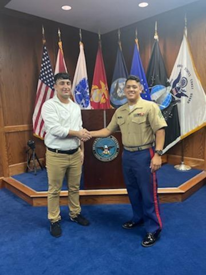 Farmanullah Siddiqi shakes hands with his recruiter, Sgt. Alexander Diaz, after taking the oath of enlistment at the Military Entrance Processing Station, Tampa, Florida, July 14, 2022. After completion of Marine Corps Recruit Training, Siddiqi will serve as an infantryman. (Courtesy Photo from Sgt. Alexander Diaz)