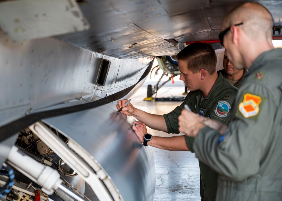 Commanders, honorary commanders and members of the 309th Fighter Squadron “Ducks” sign a retiring F-16 Fighting Falcon aircraft Sept. 6, 2022, at Luke Air Force Base, Arizona.