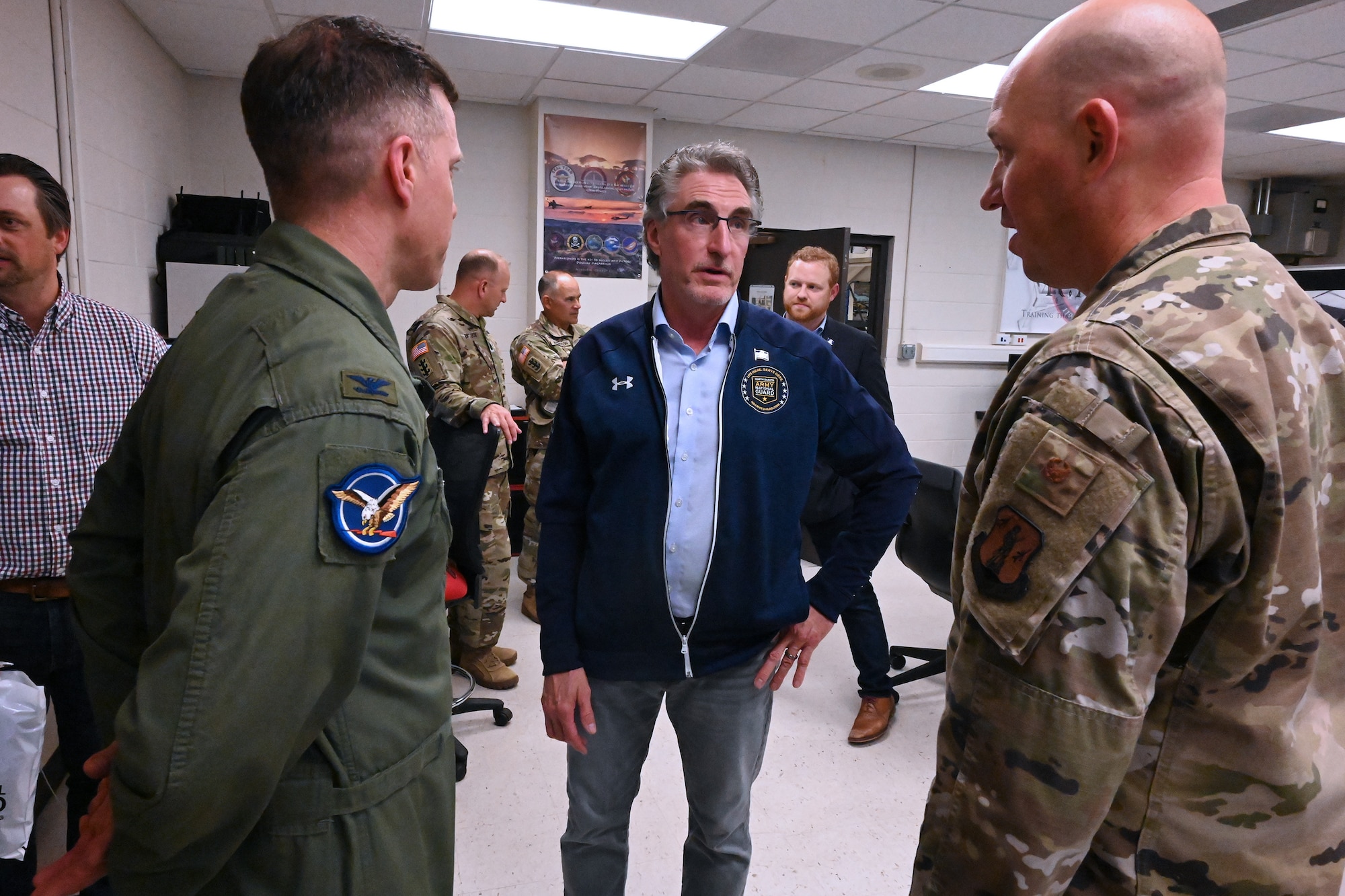 North Dakota Governor Doug Burgum stands among North Dakota Air National Guard members in military uniforms as he visits with them about state and unit issues Sept. 14, 2022.