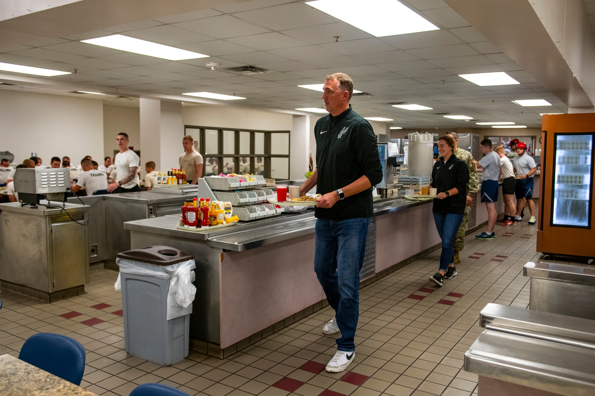 Phil Cullen, San Antonio Spurs director of basketball strategy, and Alison Nabatoff, San Antonio Spurs talent academy associate, grab lunch at the special warfare performance dining facility at Joint Base San Antonio-Lackland, Texas, Aug. 15, 2022. The SWTW and Spurs met to discuss ideas and talk strategy on human performance. (U.S. Air Force photo by Brian J. Valencia)