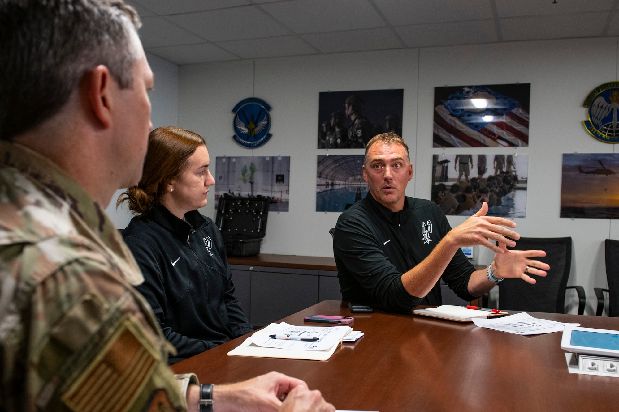 Phil Cullen, right, San Antonio Spurs director of basketball strategy, and Alison Nabatoff, center, San Antonio Spurs talent academy associate, discuss human performance integration with Col. Nathan Colunga, Special Warfare Training Wing commander, and other senior leaders from SWTW at Joint Base San Antonio-Chapman Annex, Texas, Aug. 15, 2022. The SWTW and Spurs met to discuss ideas and talk strategy on human performance. (U.S. Air Force photo by Brian J. Valencia)