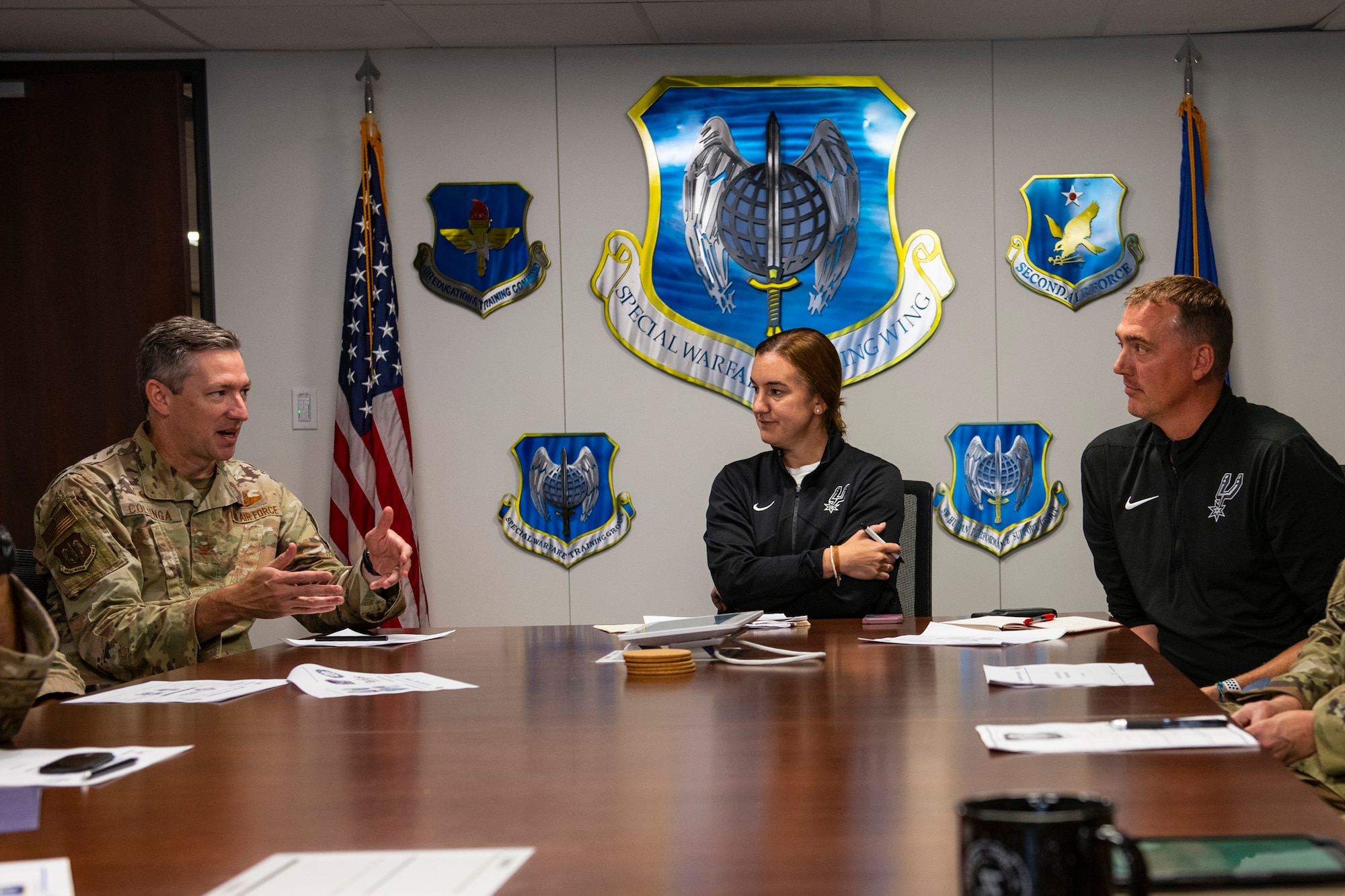 Col. Nathan Colunga, left, Special Warfare Training Wing commander, discusses human performance integration with Alison Nabatoff, center, San Antonio Spurs talent academy associate and Phil Cullen, right, San Antonio Spurs director of basketball strategy, at Joint Base San Antonio-Chapman Annex, Texas, Aug. 15, 2022. The SWTW and Spurs met to discuss ideas and talk strategy on human performance. (U.S. Air Force photo by Brian J. Valencia)