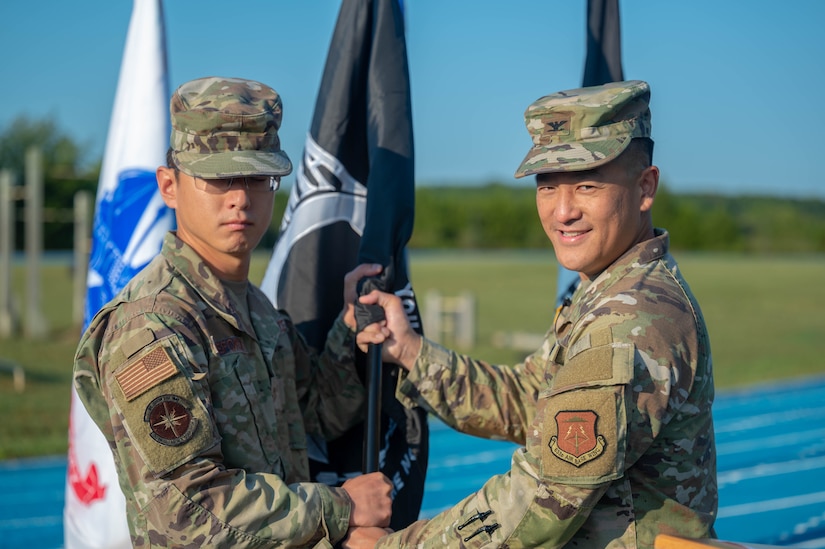 U.S. Air Force, Col. Harry Hung, Joint Base Langley-Eustis vice commander, passes the POW/MIA Recognition Day flag to Tech. Sgt. Christopher DeForge, Air Force Sergeants Association, Chapter 358 president at JBLE, Virginia, Sept. 15, 2022.