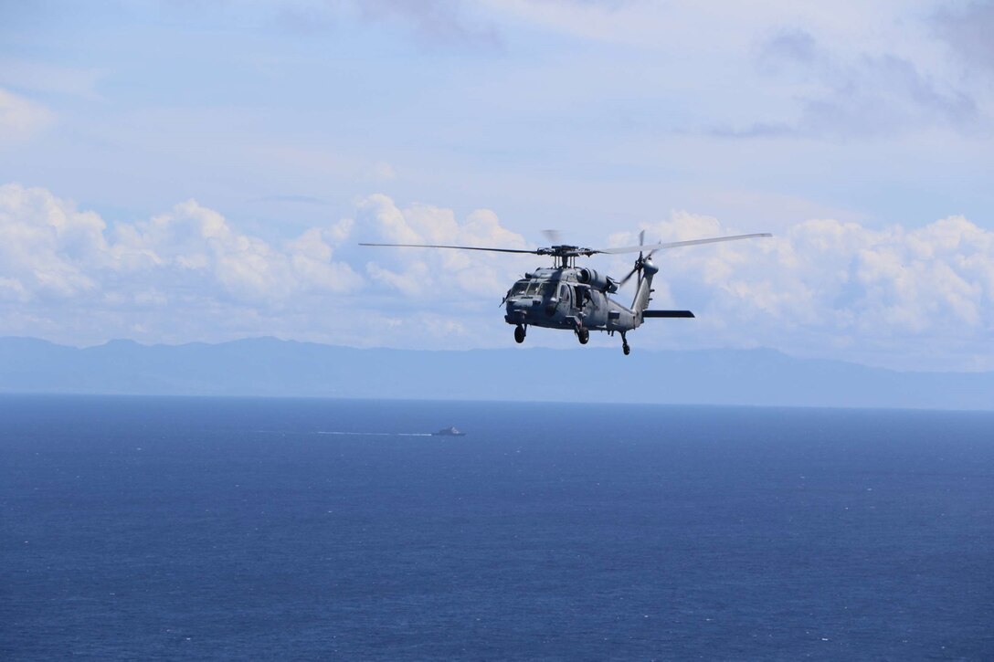 An MH-60S Sea Hawk helicopter assigned to Helicopter Sea Combat Squadron (HSC) 28, Detachment 8, participates in a photo exercise overlooking the Freedom-variant littoral combat ship USS Billings (LCS 15) in the Caribbean Sea, Sept. 10, 2022. Billings is deployed to the U.S. 4th Fleet area of operations to support Joint Interagency Task Force South’s mission, which includes counter-illicit drug trafficking missions in the Caribbean and Eastern Pacific.