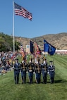 A color guard marches in a pass in review.