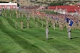 Soldiers and airmen stand in formation before marching in a pass in review.