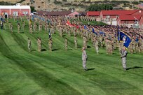 Soldiers and airmen stand in formation before marching in a pass in review.