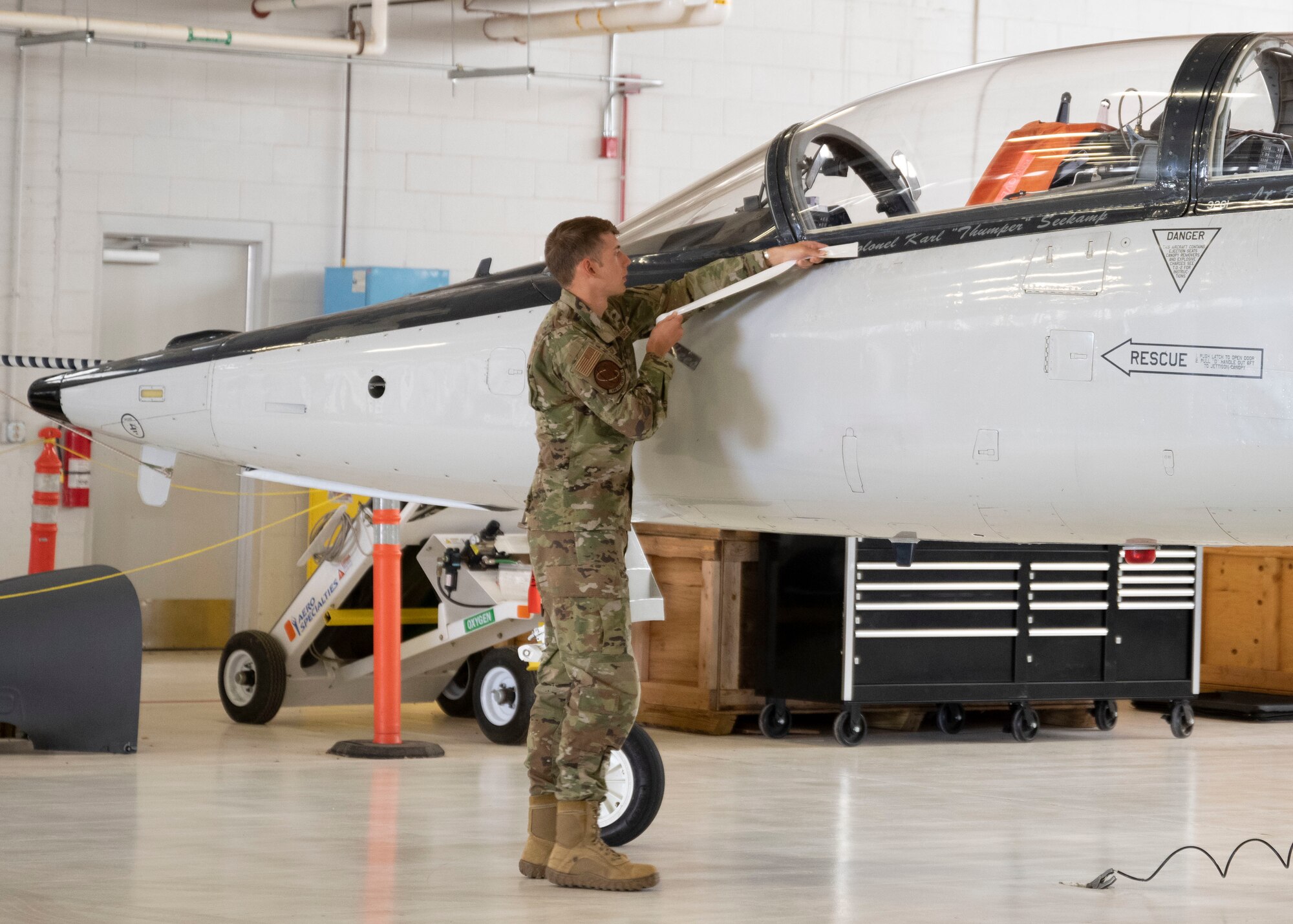 An Airman reveals the name of the 704th Test Group incoming commander by placing it on the aircraft during a change of command ceremony, at Holloman Air Force Base, New Mexico, Sep. 9, 2022.
