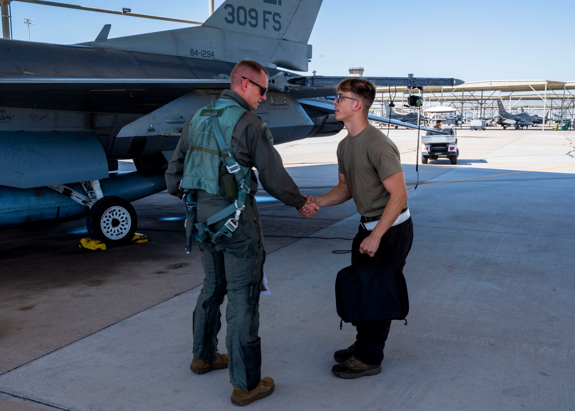 U.S. Air Force Lt. Col. Matthew “Fuse” Eldredge, 309th Fighter Squadron “Ducks” former commander, greets Airman 1st Class Keilani Durfey, 310th Aircraft Maintenance Unit crew chief, outside the retiring Block 25 F-16 Fighting Falcon Sept. 6, 2022, at Luke Air Force Base, Arizona.
