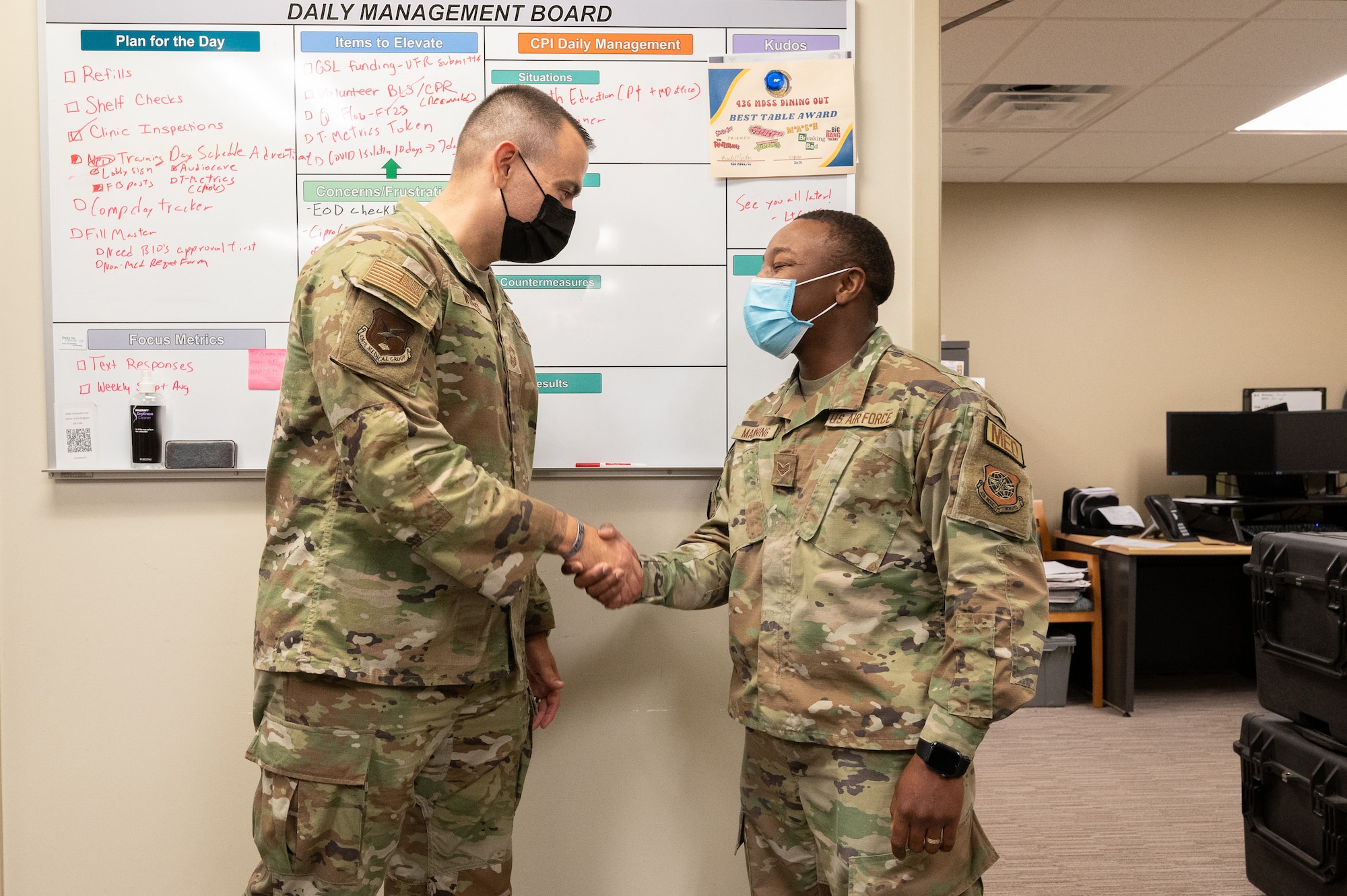 Chief Master Sgt. James Woods, left, Air Mobility Command command chief of medical enlisted force, coins Senior Airman Deanfernee Manning, 436th Medical Group pharmacy technician, Dover Air Force Base, Delaware, Sept. 20, 2022. Woods also toured the Bedrock Innovation Lab and Air Force Mortuary Affairs Operations. (U.S. Air Force photo by Mauricio Campino)