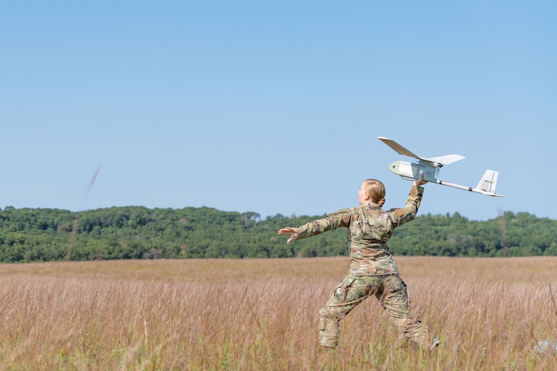 A soldier launches a small unmanned aerial vehicle.