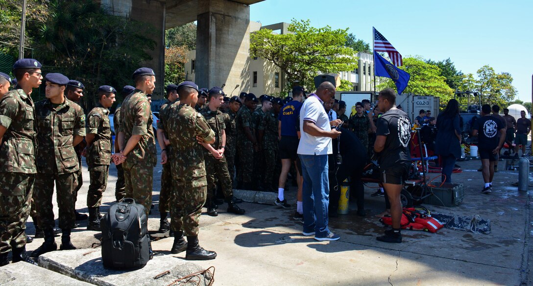 RIO DE JANEIRO – Brazilian military members watch as U.S. Navy divers, assigned to Mobile Diving and Salvage Unit 2 (MDSU-2) prepare to conduct diving operations during UNITAS LXIII, Sept. 19, 2022. UNITAS is the world’s longest-running maritime exercise. Hosted this year by Brazil, it brings together multinational forces from Brazil, Cameroon, Chile, Colombia, Dominican Republic, Ecuador, France, Guyana, Jamaica, Mexico, Namibia, Panama, Paraguay, Peru, South Korea, Spain, United Kingdom, Uruguay, and the United States conducting operations in and off the coast of Rio de Janeiro. The exercise trains forces to conduct joint maritime operations through the execution of anti-surface, anti-submarine, anti-air, amphibious and electronic warfare operations that enhance warfighting proficiency and increase interoperability among participating naval and marine forces. (U.S. Navy photo by Mass Communication Specialist 3rd Class Jahlena Royer/Released)