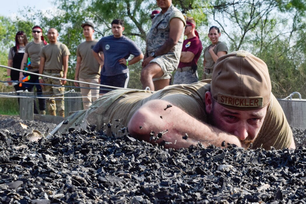 Tech. Sgt. Michael Strickler, 433rd Security Forces Squadron defender, crawls through an obstacle course during a combat dining-in event at Joint Base San Antonio-Chapman Training Annex, Texas, Sept. 10, 2022. The event was hosted by the 433rd SFS to raise morale and promote comradery within the wing. (U.S. Air Force photo by Senior Airman Brittany Wich)