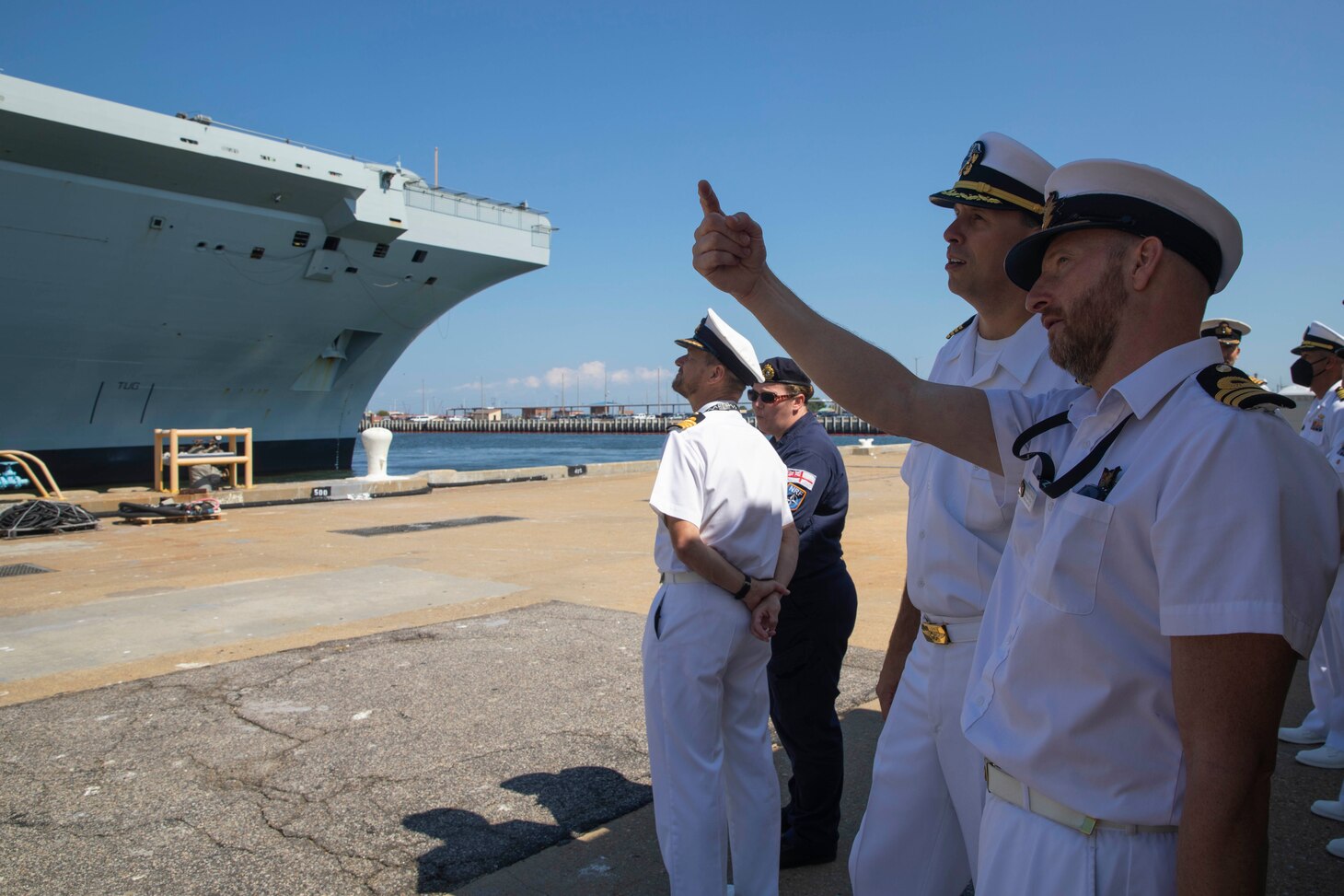 Capt. Christopher Purcell, executive officer of the amphibious assault ship USS Wasp (LHD 1) talks with Cmdr. Matt Tazewell, the staff aviation officer of the British Royal Navy aircraft carrier HMS Queen Elizabeth (RO8), on pier 12 in Naval Station Norfolk