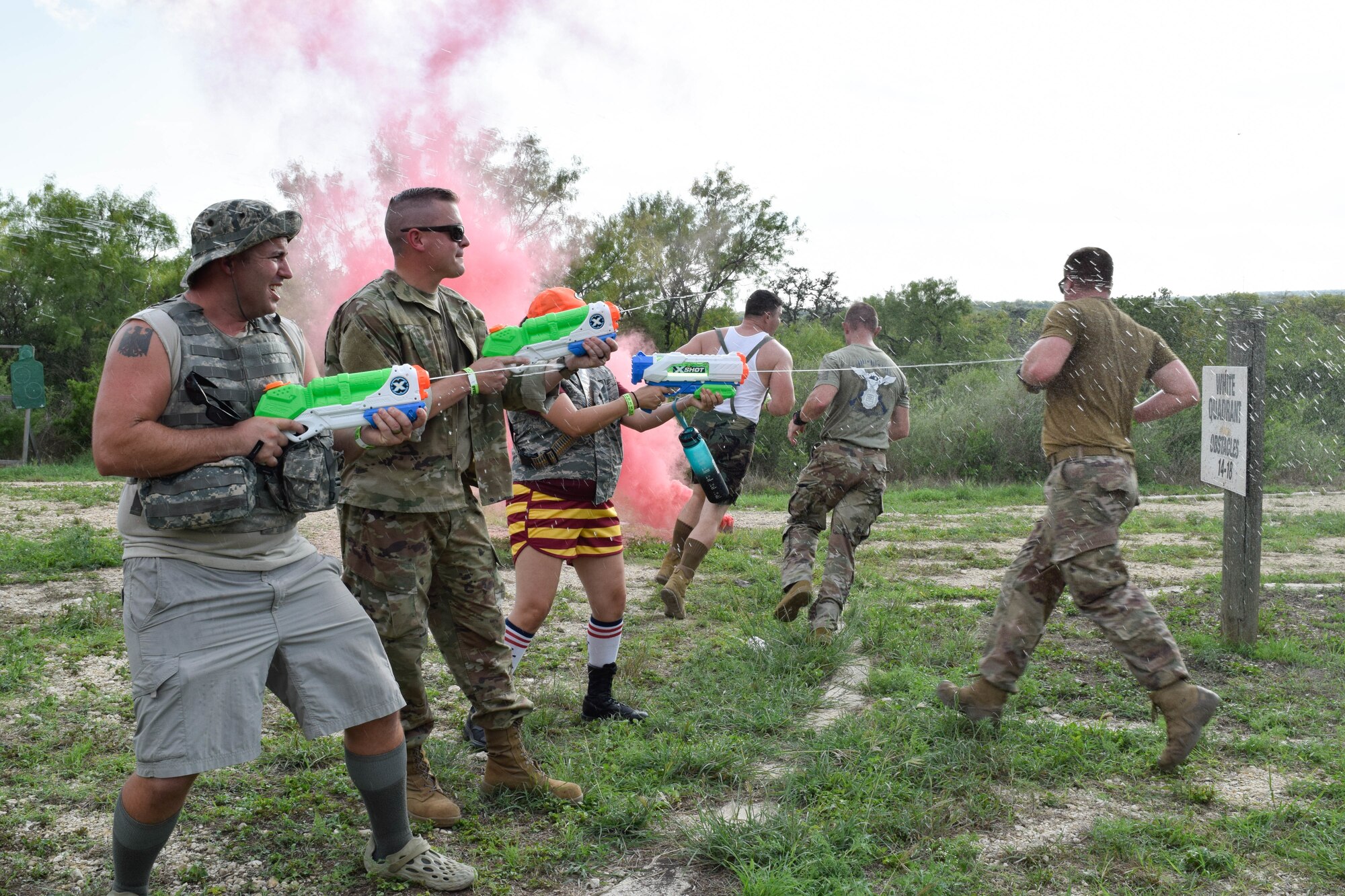 Airmen with the 433rd Airlift Wing shoot water at participants during a combat dining-in event at Joint Base San Antonio-Chapman Training Annex, Texas, Sept. 10, 2022. The event was hosted by the 433rd SFS to build camaraderie and rapport within the wing. (U.S. Air Force photo by Senior Airman Brittany Wich)
