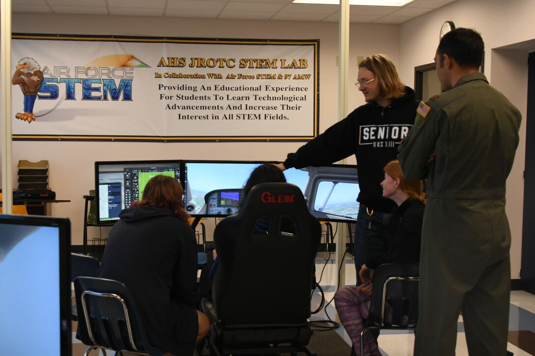 U.S. Air Force Maj. Evan Lomeli, 58th Airlift Squadron pilot, observes students operate an X-Plane 11 simulator at Altus High School, Altus, Oklahoma, Sept. 21, 2022. Every week throughout the school year, pilots have the opportunity to volunteer to help educate the students using the simulators. (U.S. Air Force photo by Airman 1st Class Miyah Gray)