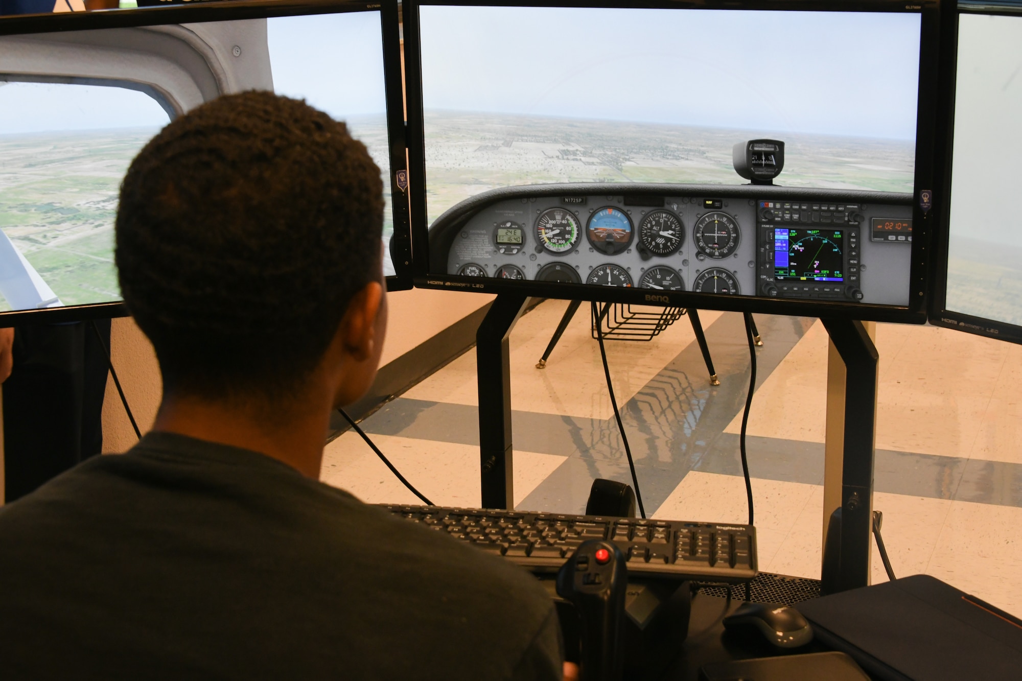A high school student simulates flying an aircraft on an X-Plane 11 simulator during an aviation course at Altus High School, Altus, Oklahoma, Sept. 21, 2022. The simulators allow students to practice flying over 10 different airframes, familiarizing themselves with basic aircraft operations. (U.S. Air Force photo by Airman 1st Class Miyah Gray)