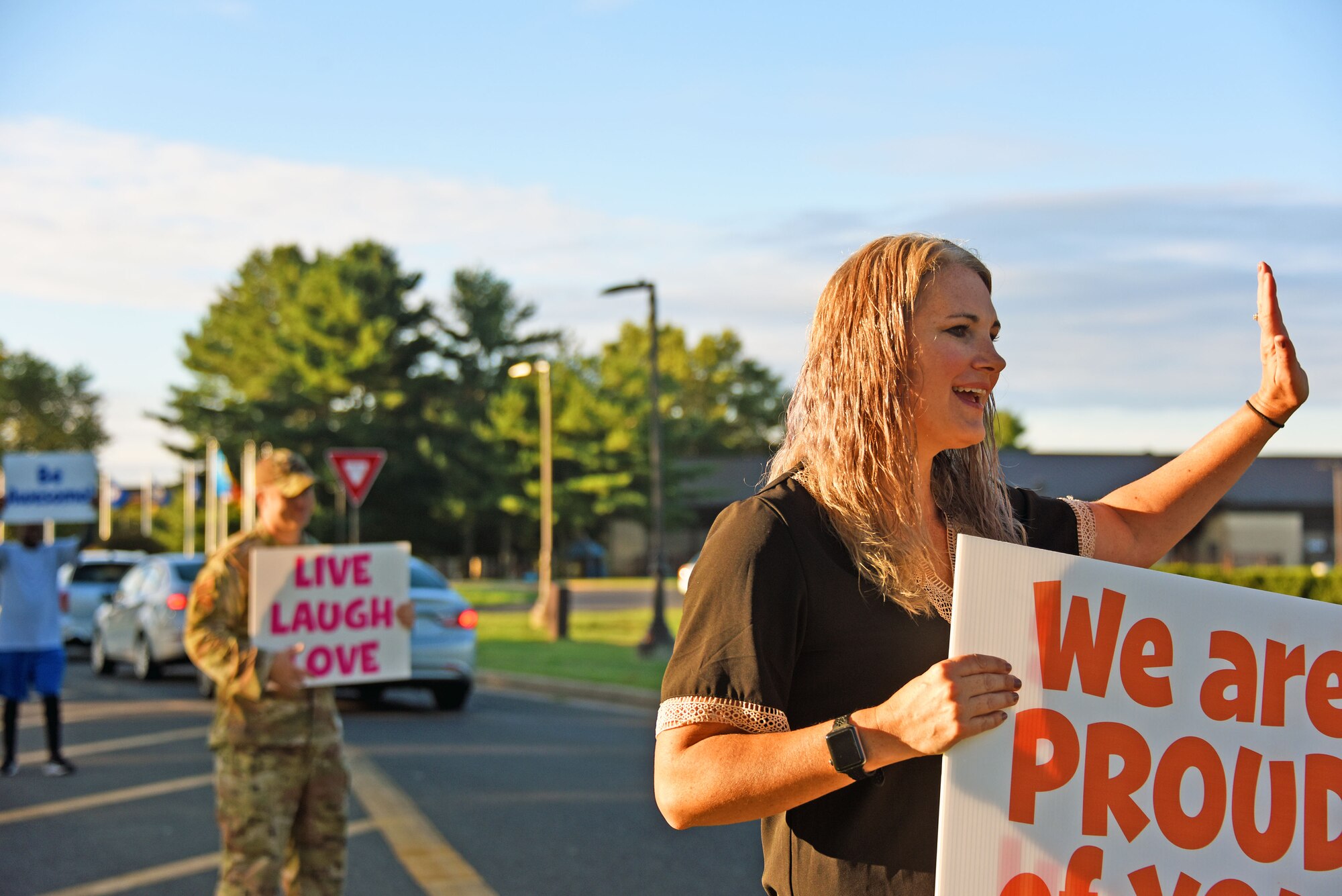 Suicide Prevention Awareness community support coordinator and other participants greet drivers coming through the McGuire gate while holding signs on Joint Base McGuire-Dix-Lakehurst, N.J.