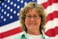 Suicide Prevention Awareness manager poses for a picture in front of the U.S. flag.