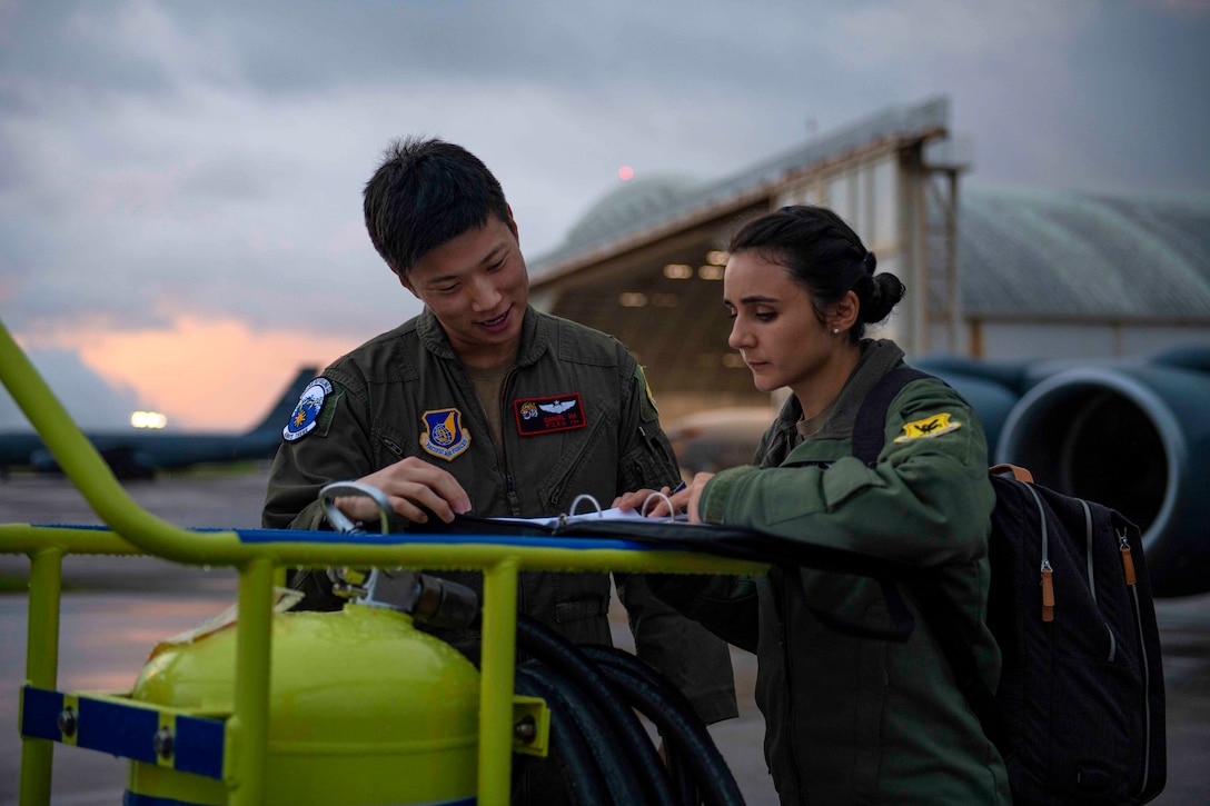 Two airmen read over papers.