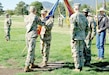 Col. Patrick L. Pollak, center assumes command of the 11th Expeditionary Combat Aviation Brigade by accepting the unit guidon from Col. Lindsey Halter, commanding officer, Army Reserve Aviation Command, during a ceremony at Founders Field Sept. 17, 2022. (Photo by Scott Prater)