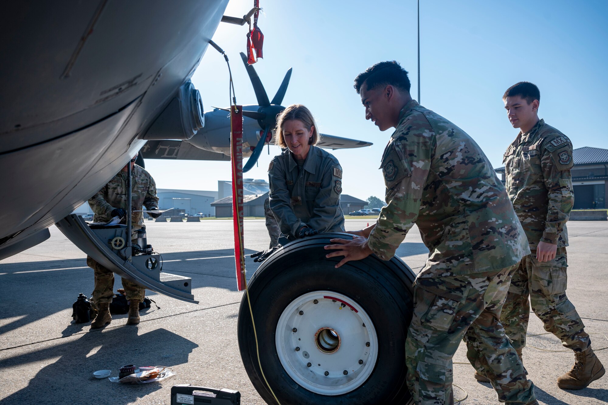 Airmen change a tire on an aircraft.
