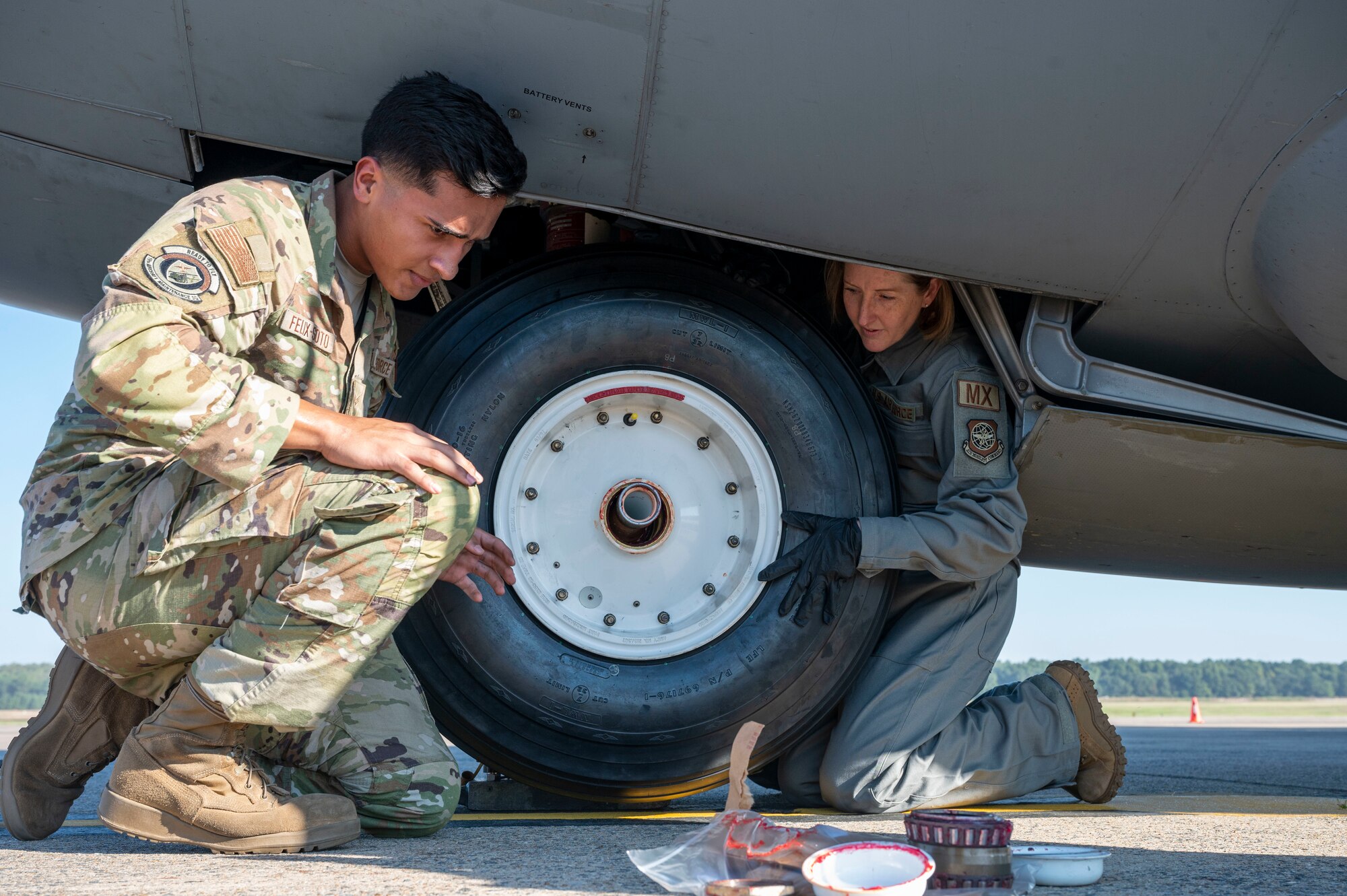 Airmen change a tire on an aircraft.