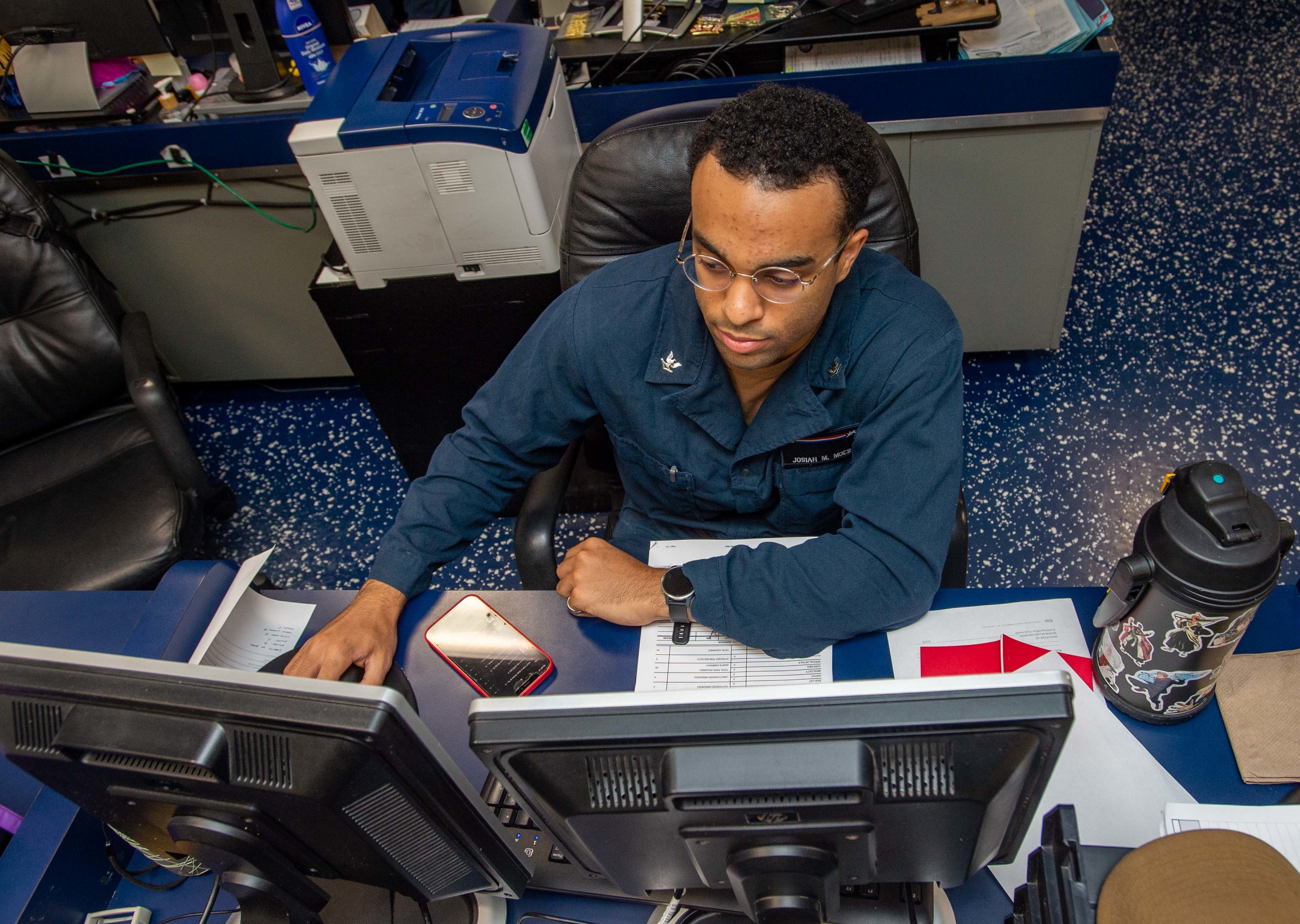 Machinist's Mate (Nuclear) 3rd Class Josiah Moes generates a muster report aboard USS Ronald Reagan (CVN 76) in the Philippine Sea.