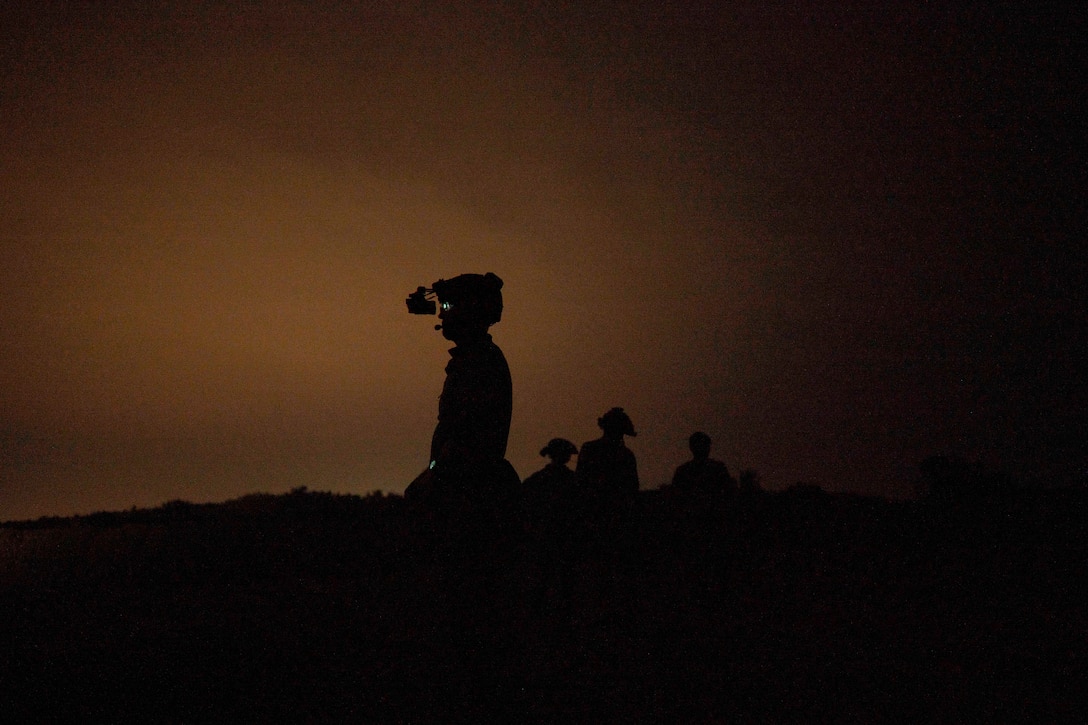 U.S. and Ivorian troops wearing protective gear gather under a sunlit sky.
