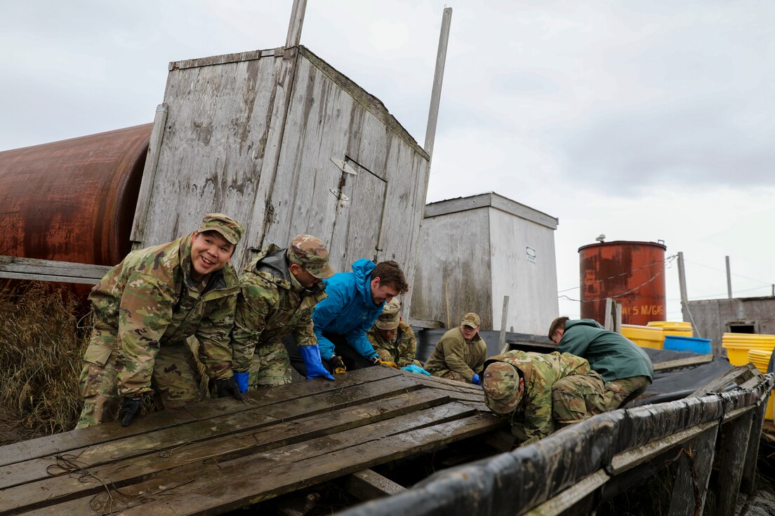Alaska National Guardsmen of Joint Task Force-Bethel clear storm debris from a boardwalk in Newtok, Alaska as part of Operation Merbok Response, Sept. 22, 2022. Approximately 100 members of the Alaska Organized Militia, which includes members of the Alaska National Guard, Alaska State Defense Force and Alaska Naval Militia, were activated following a disaster declaration issued Sept. 17 after the remnants of Typhoon Merbok caused dramatic flooding across more than 1,000 miles of Alaskan coastline. (Alaska National Guard photo by 1st Lt. Balinda O'Neal)