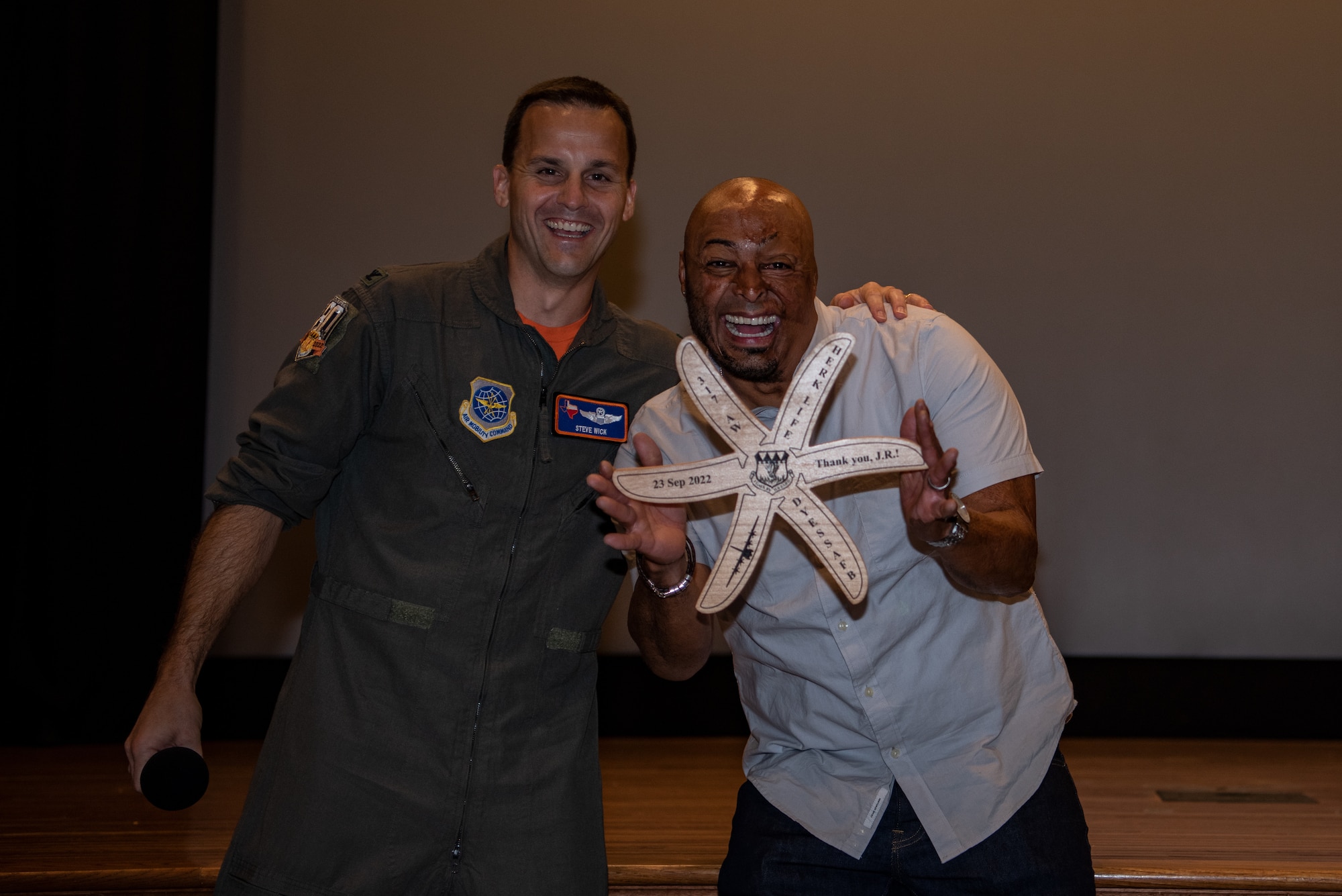 Col. Steven Wick, 317th Airlift Wing vice commander gifts J.R. Martinez, a combat veteran and motivational speaker, during the 317th AW resiliency training day at Dyess Air Force Base, Texas, Sept. 23, 2022. The 317th AW reached out to Martinez to speak to the Airmen about resiliency. (U.S. Air Force photo by Airman 1st Class Ryan Hayman)