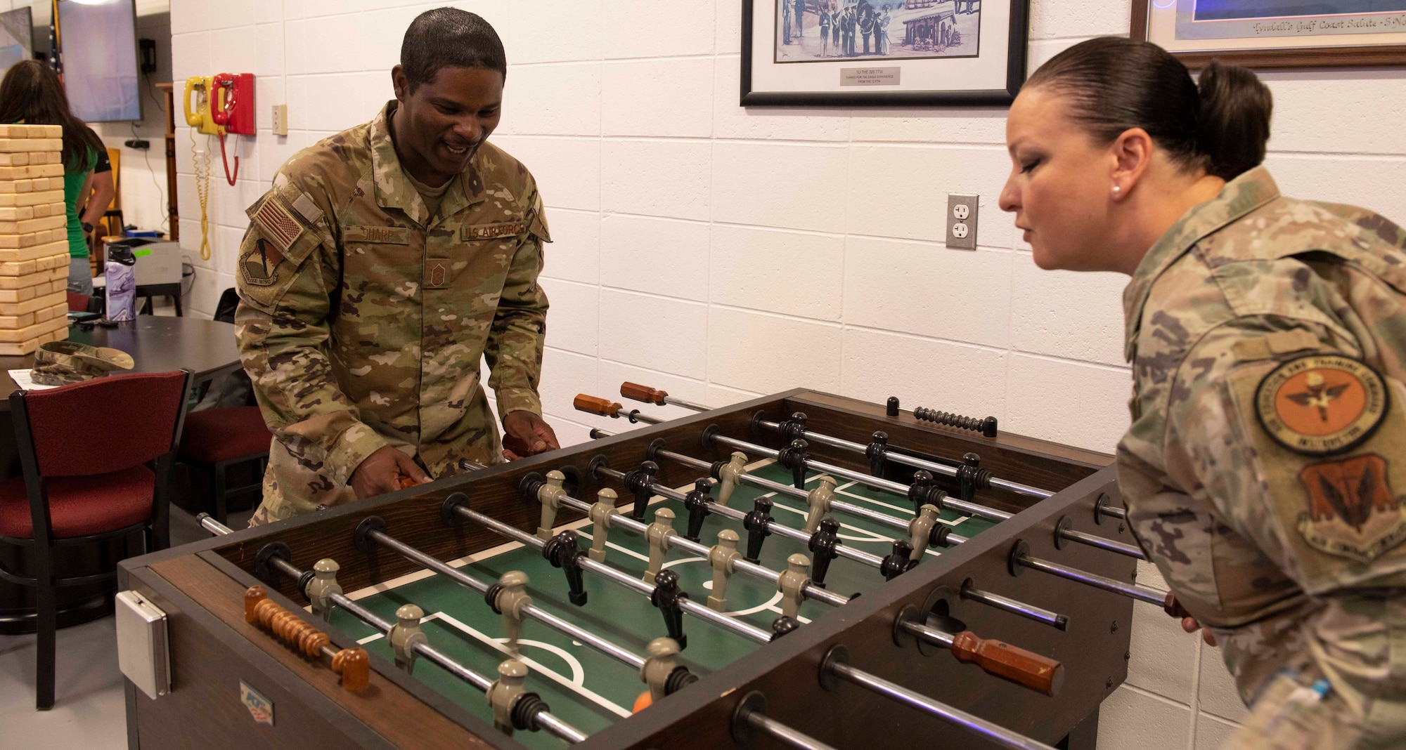Two uniformed members play foosball.