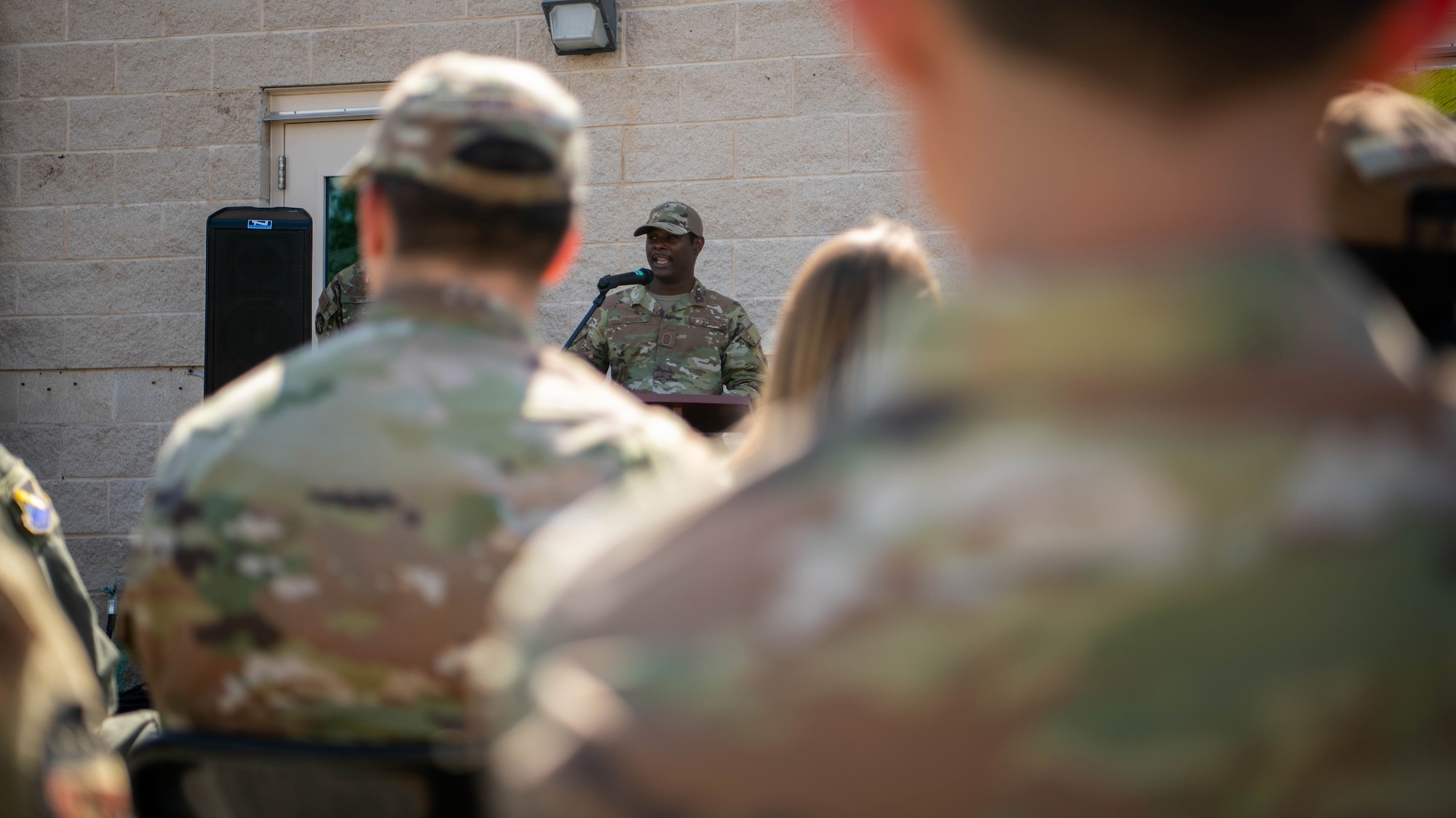 Uniformed member address audience from a podium.